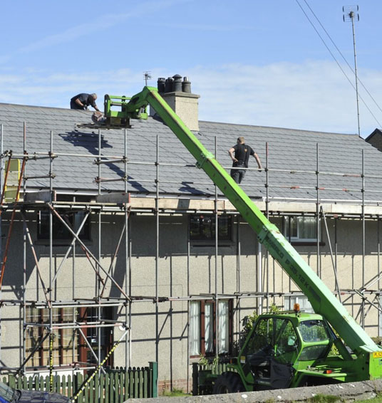 Apartment being boarded up and having a new roof installed