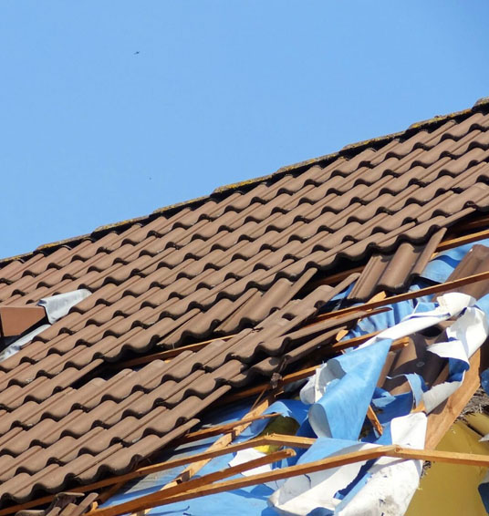 Damaged roof with torn off shingles