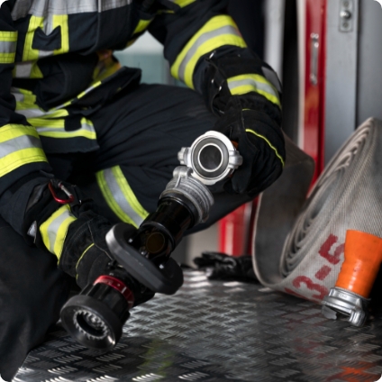 Firefighter with firehouse and nozzle.